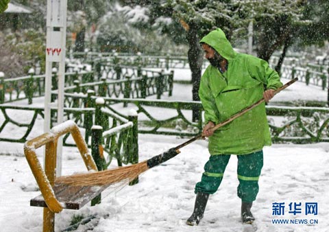 11月8日，一名男子在伊朗首都德黑兰街头扫雪。当日，德黑兰迎来今冬第一场雪。